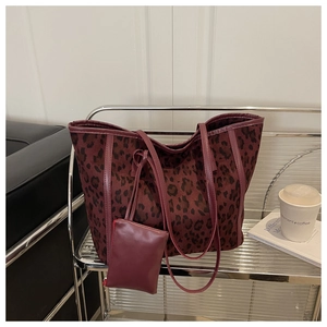Detail of burgundy leopard print tote bag in suede texture with a matching zipper pouch