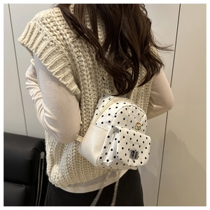 Détail du mini sac à dos à pois avec bandoulières en chaîne et écusson hamburger