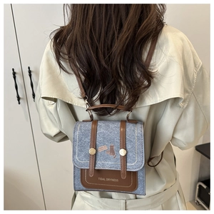 Detail of grey felt mini backpack with leather straps and cat graphic print