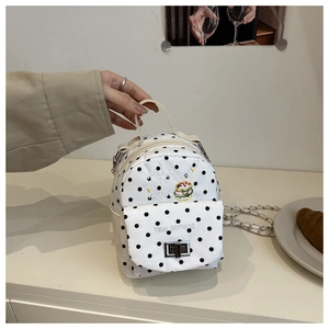 Detail of white polka dot mini bag with burger embroidery and metal chain strap