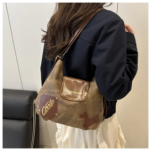 Dettaglio borsa tote vintage in tela marrone con toppe in pelle e tracolla lunga elegante