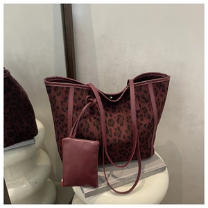 Detail shot of leopard print tote bag set with matching pouch on minimalist stone stand