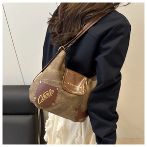Dettaglio ravvicinato della borsa in tela marrone con applicazioni in pelle e borchie