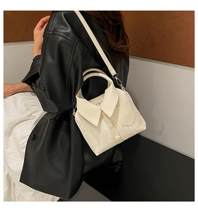Close-up of cream white shirt-shaped handbag with button details and textured faux leather