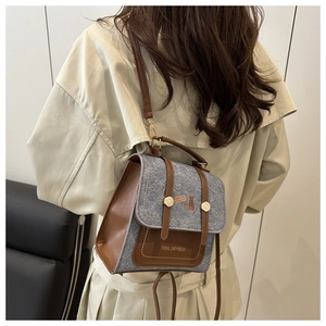 Detail of color-block mini backpack in grey tweed and brown leather on model