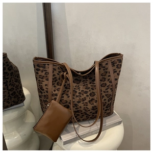 Macro view of leopard print tote bag detailing canvas texture and brown leather strap