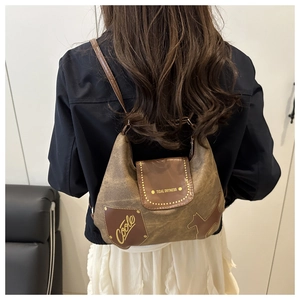 Dettaglio della borsa tote marrone vintage con scritta Coole e sagoma di cucciolo
