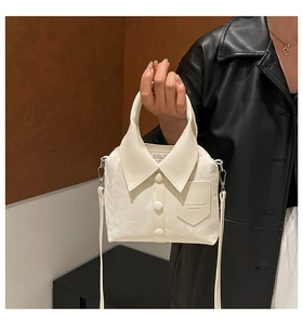 Detail of creative white shirt-style handbag with lapel, buttons, and silver hardware