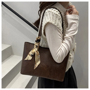 Detail of coffee brown retro PU leather tote with patterned silk scarf handle decor