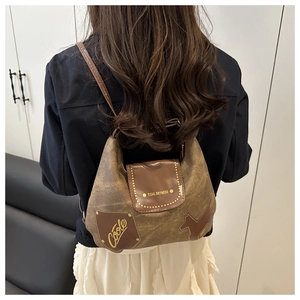 Dettaglio della borsa tote in tela vintage con toppe in pelle e rivetti in metallo