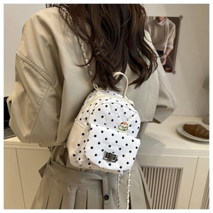 Détail d'un mini sac à dos blanc à pois avec broderie burger et bandoulière chaîne