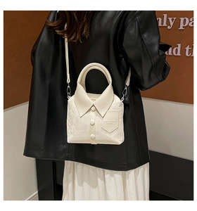 Detailed view of white shirt-shaped crossbody bag with collar and button accents