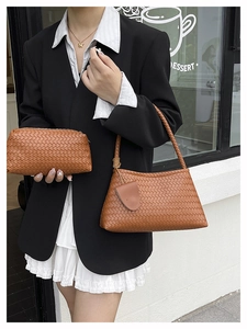 Detail of brown woven leather tote and matching pouch set with textured shoulder strap