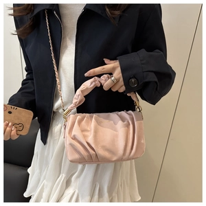 Vue détaillée du sac nuage plissé rose avec chaîne dorée élégante et textures douces