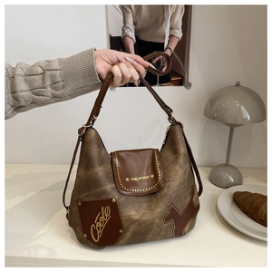 Dettaglio della borsa tote marrone vintage con patch gatto e tasca decorativa trendy