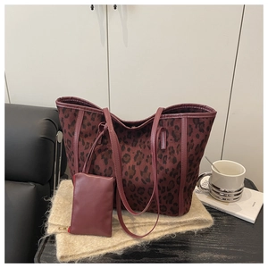 Detail of burgundy leopard print tote bag with matching coin purse on soft beige fabric