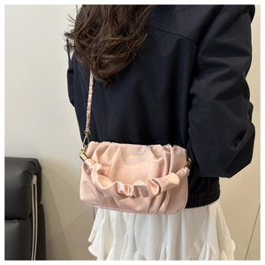 Détail du sac nuage plissé rose clair avec lettrage métallique et bandoulière chaîne