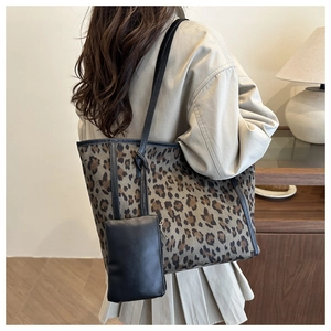 Detailed back view of a large leopard print tote bag with black leather trim and small pouch