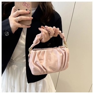 Détail du sac à main nuage plissé rose avec logo doré et texture satinée élégante