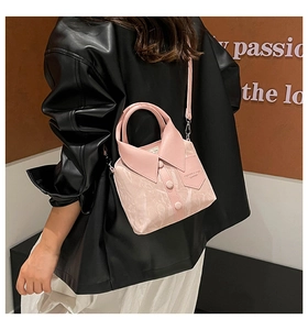 Detailed view of a pink handbag with shirt collar design and detachable shoulder strap