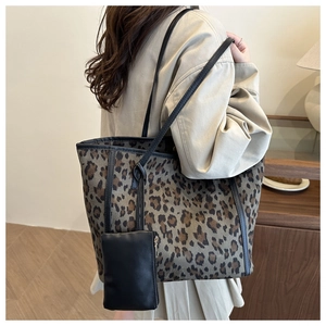 Detailed side view of large leopard print tote bag with black leather straps and sub-bag