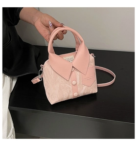 Detail of pink faux leather handbag featuring creative shirt collar and button design