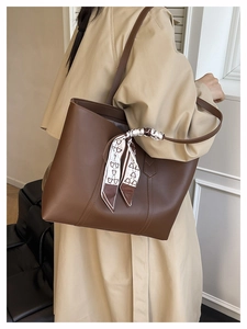 Detail eines Seidentuchs mit Bärenmuster am Griff einer dunkelbraunen Leder-Shopper