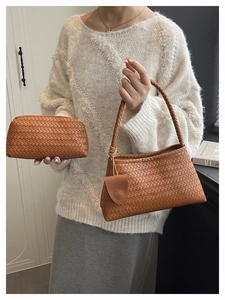 Detail of woven caramel leather shoulder bag and pouch styled with white sweater