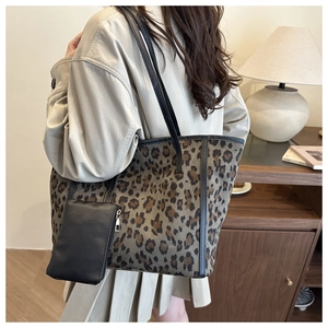 Dettaglio della borsa tote in pelle scamosciata leopardata con portamonete nero e tracolla fine