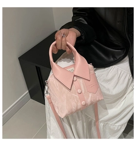Detail of pink shirt-style handbag with lapel handle and decorative button accents