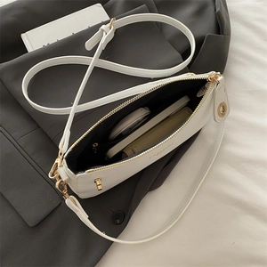White pebbled leather shoulder bag with gold hardware showing interior storage capacity