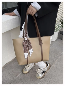 Detail of khaki tote bag featuring brown shoulder straps and bear print silk scarf accent