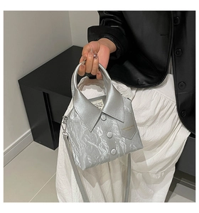 Detailed view of creative silver shirt-shaped handbag with unique collar and button accents