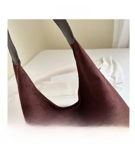 Detail shot of the dark burgundy suede tote bag showing stitching and brown leather straps