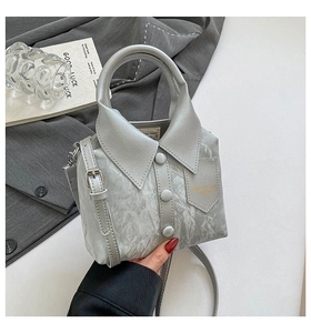 Detail of grey shirt-shaped handbag with marble texture and lapel design elements