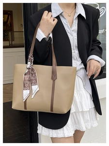 Detail of khaki tote bag with brown straps and bear print silk scarf accessory