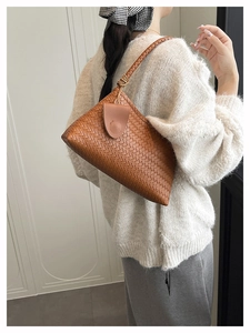 Detailed side view of brown woven tote bag featuring textures and shoulder strap