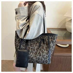 Leopard print tote bag with small black zipper pouch and slim shoulder straps on model
