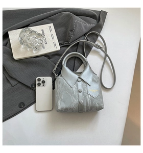 Detail shot of a creative shirt-style silver tote bag with lapel and button accents