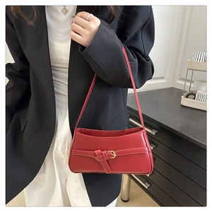 Dettaglio della borsa baguette in pelle PU rossa con fibbia e texture liscia lucida