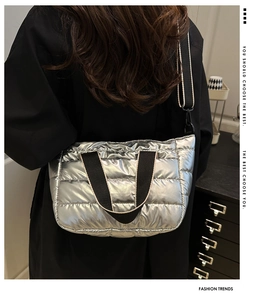Detailed view of silver metallic quilted puffer bag with black adjustable strap and texture