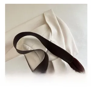 Detail of broad suede shoulder strap and leather piping on brown retro tote bag