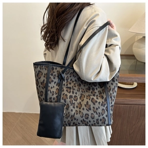 Leopard print tote bag with black leather pouch accessory shown on a model's shoulder