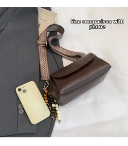 Borsa a bauletto retrò marrone con tracolla geometrica e telefono per confronto