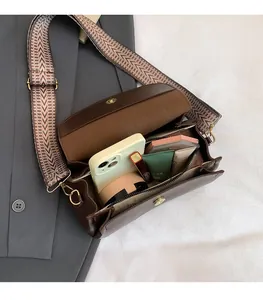 Dettaglio dell'interno capiente e della tracolla larga intrecciata di questa borsa vintage