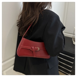Minimalist red underarm bag featuring decorative belt buckle and sleek synthetic leather