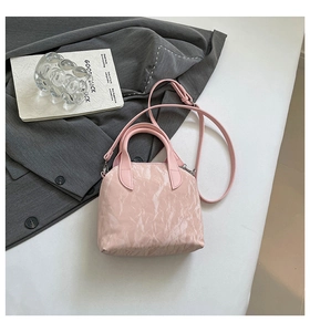 Detailed view of pink pleated handbag with marble texture and silver hardware details
