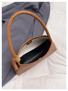 Top view of brown woven handbag showing magnetic closure and interior storage space