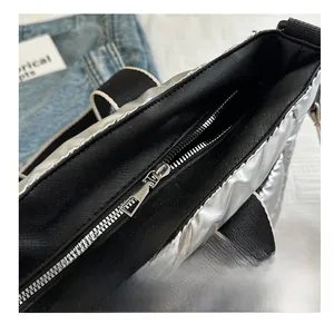 Close-up of smooth zipper on silver quilted tote bag with metallic texture