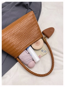 Detailed top view of brown woven tote bag interior showing capacity with umbrella and phone